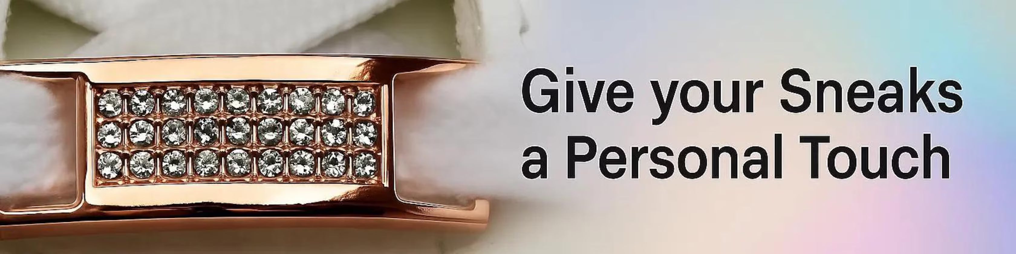Elegante goldene Lacelock mit funkelnden Kristallen vor pastellfarbenem Hintergrund mit Text "Give your Sneaks a Personal Touch"